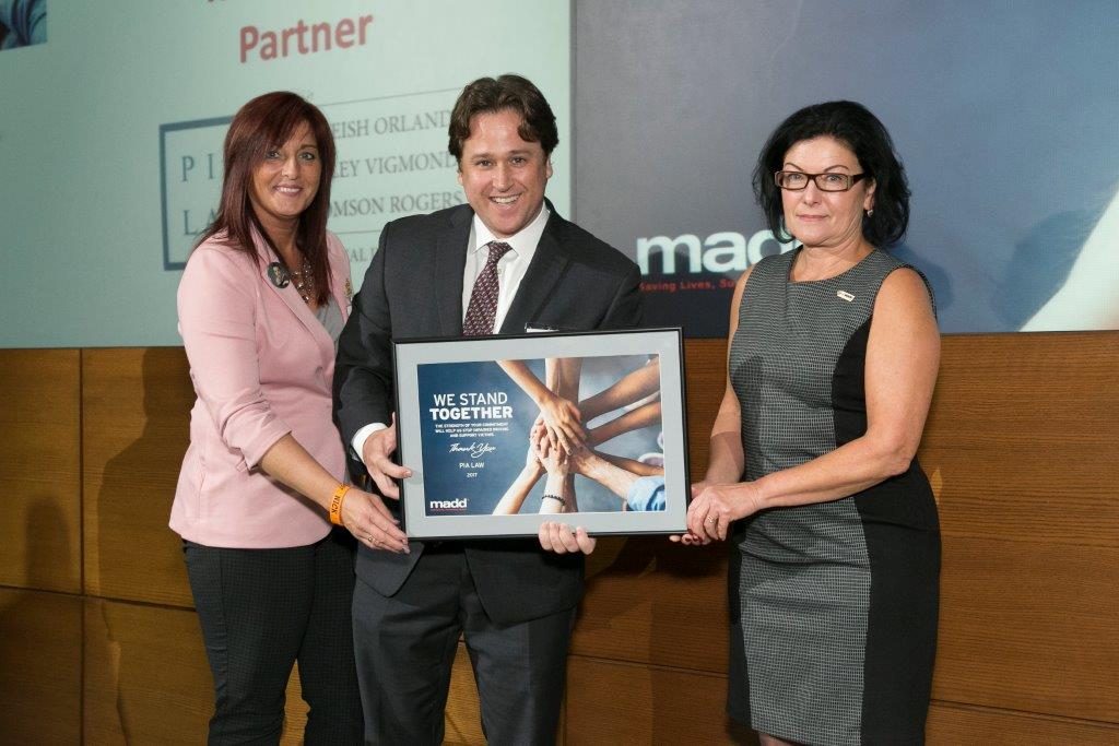 Thomson Rogers' Ian Furlong, on behalf of PIA Law, accepts an award in recognition of PIA Law's support of MADD Canada 