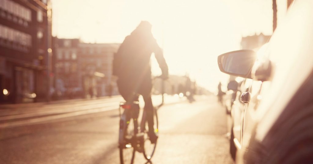cyclist riding by cars