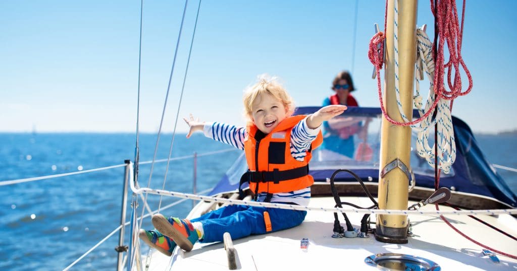 child with life jacket on boat