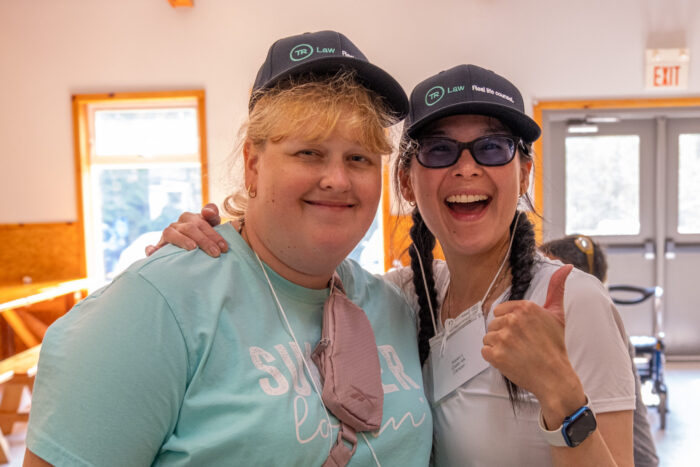 Camp Dawn campers pose in front of the camera, wearing Thomson Rogers hats